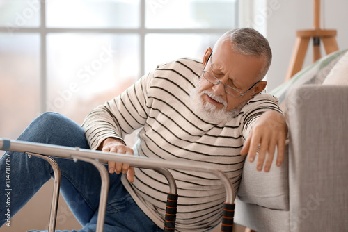 Senior man with walker sitt...