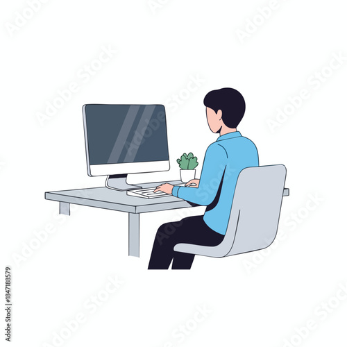 A person with dark hair, a light blue shirt, is at a desk using a computer