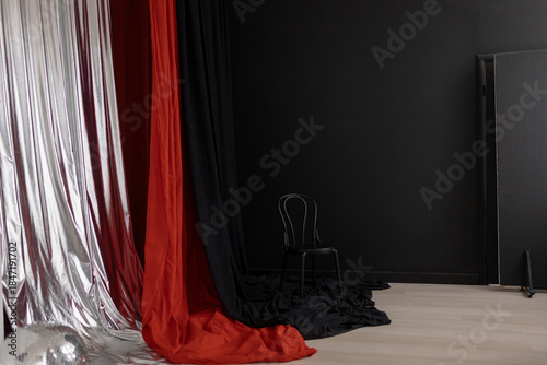 Studio with curtains, chair and black wall