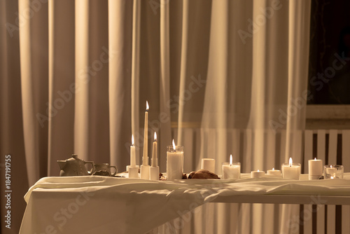 A collection of lifestyle images featuring a minimalist beige interior with a cozy sofa, a vinyl record player setup, and an elegant table decorated with numerous burning candles and pampas grass