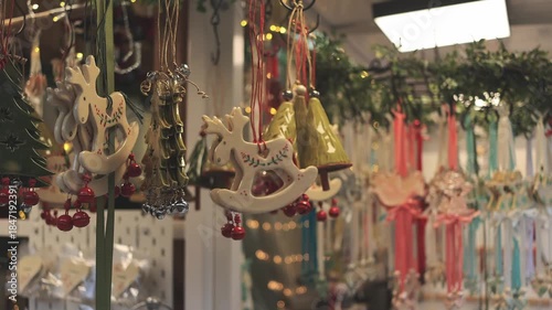 Ceramic Christmas ornaments displayed at a European holiday market, glowing in warm winter lights and creating a cozy festive atmosphere.
