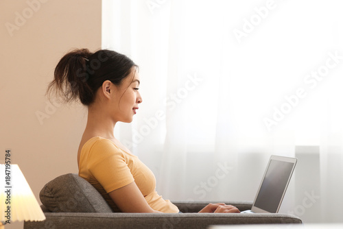 Young Asian woman using lap...