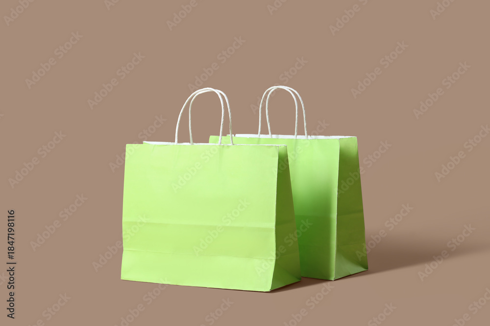 Fototapeta premium Green shopping bags on brown background