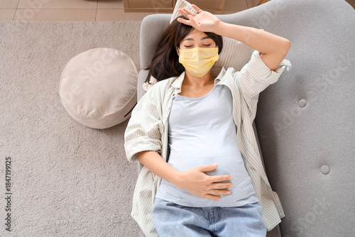 Pregnant Asian woman in yel...