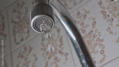 Dripping faucet, a faucet dripping continuously in slow motion, 4k, selective focus.