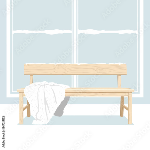 Minimalist wooden bench positioned in front of a large window with a white blanket draped over one