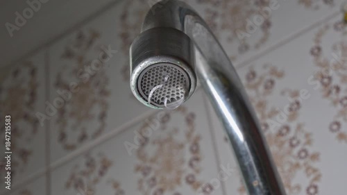 Dripping faucet, a faucet dripping continuously in slow motion, 4k, selective focus.