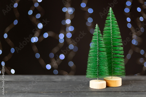 Small christmas trees on table against bokeh background