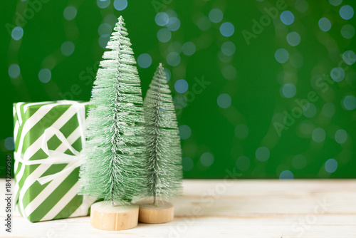 Small christmas trees on table against bokeh background