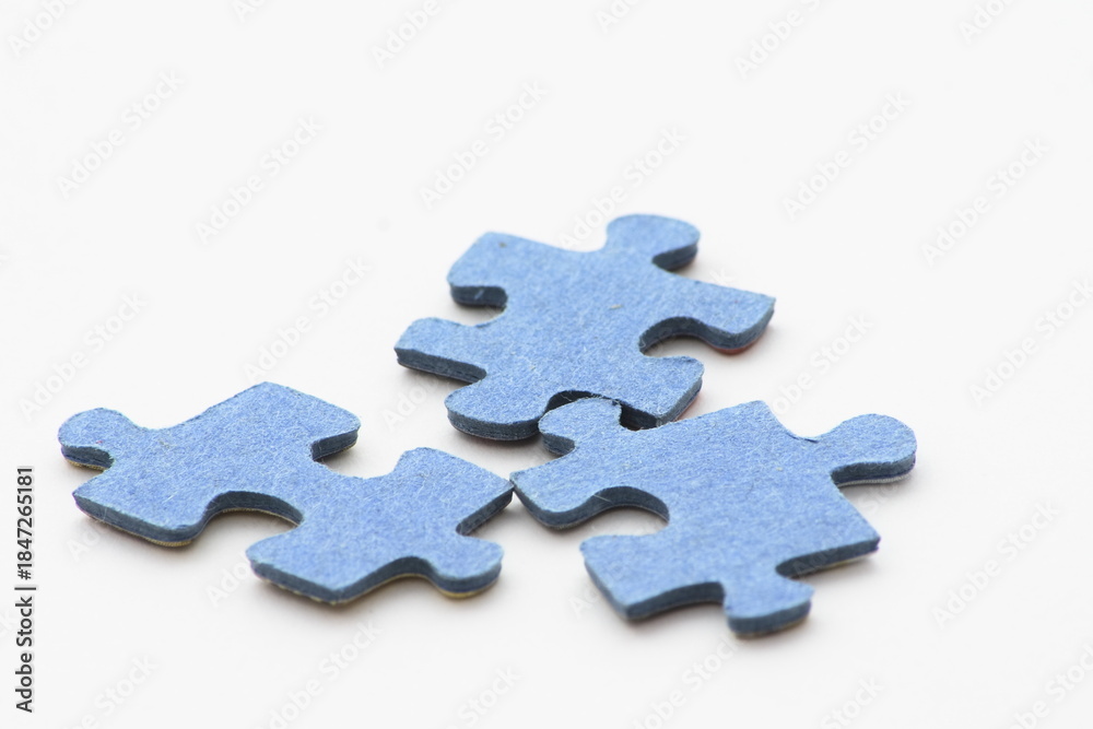 Obraz premium Blue puzzle pieces scattered on a pristine white background symbolizing problem-solving