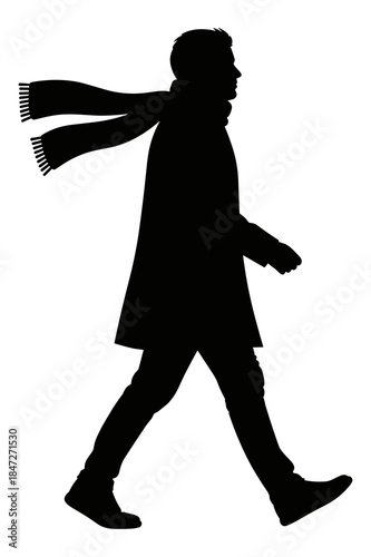 Silhouette of man walking outdoors wearing a long coat and flowing winter scarf