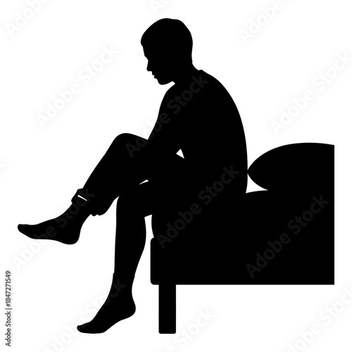 Silhouette of person sitting on bed adjusting pants leg in morning routine