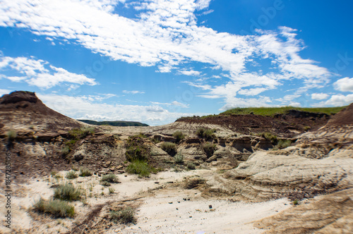 Desert Landscape With Eroded Rocks And Sparse Vegetation Under Bright Clear Blue Summer Open Sky