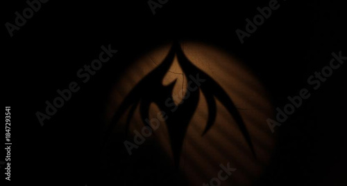 Glowing jack-o-lantern with a scary carved face and orange fire flames flickering in the dark night for a spooky Halloween celebration