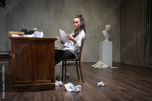 A female writer works at a typewriter, writing an essay.