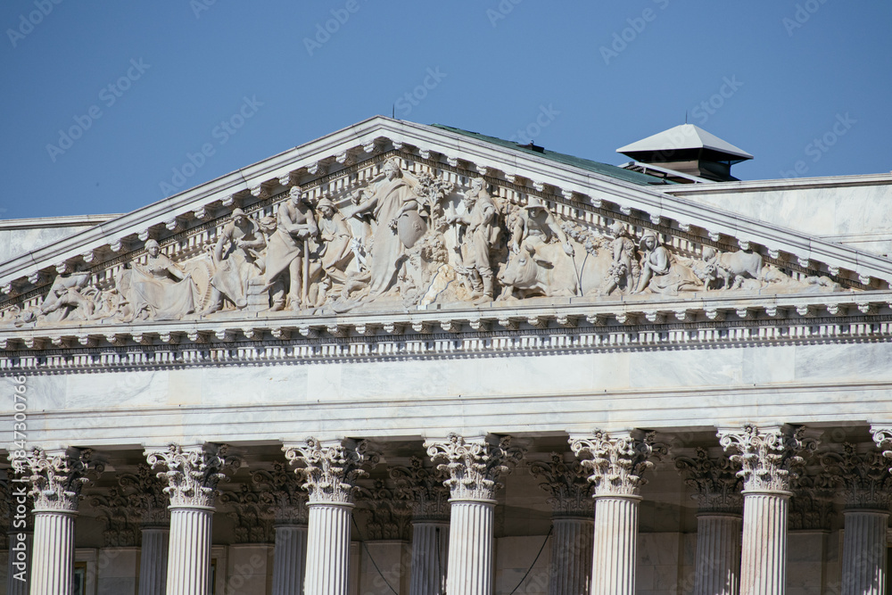 Naklejka premium United States Capitol building with iconic dome and American flag under clear blue sky in Washington DC, USA. g.