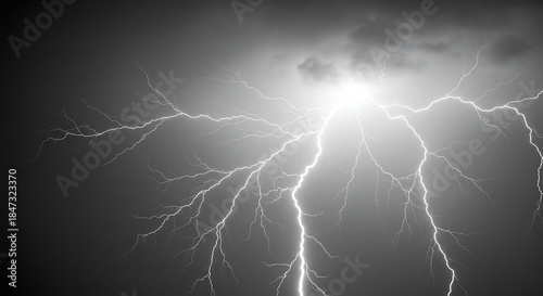 暗い雷雲を力強く引き裂く白く輝く稲妻の劇的な閃光が夜空全体を照らし出すモノクロームで捉えた自然の荒々しいエネルギーと複雑に枝分かれする放電の美しさ. AI Generated