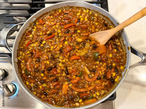 Top view of homemade organic chili in pan on top of stove being cooked