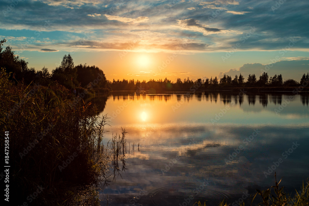 Obraz premium Beautiful summer sunset and colorful sky over the lake. Clouds are reflected in the calm water. Beauty in this world