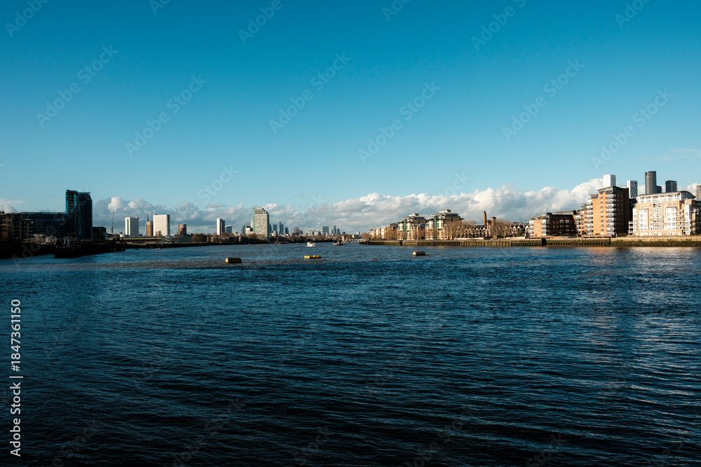 Obraz premium River thames flowing through london cityscape on a clear day