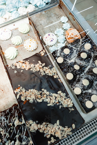 Display of various sweet treats in a bakery showing colorful desserts, chocolates, and cakes arranged on trays in a store during daytime