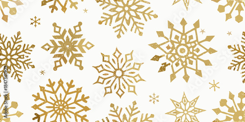 Golden snowflakes scattered on a white background create a festive winter scene