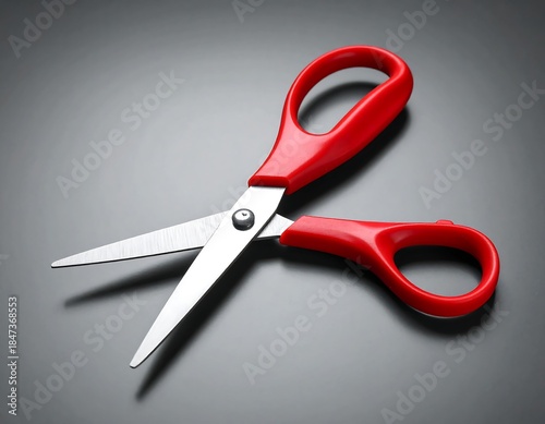 Overhead studio shot of an open, shiny pair of red handled scissors