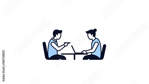 Two people sitting at a table discussing work on a laptop.