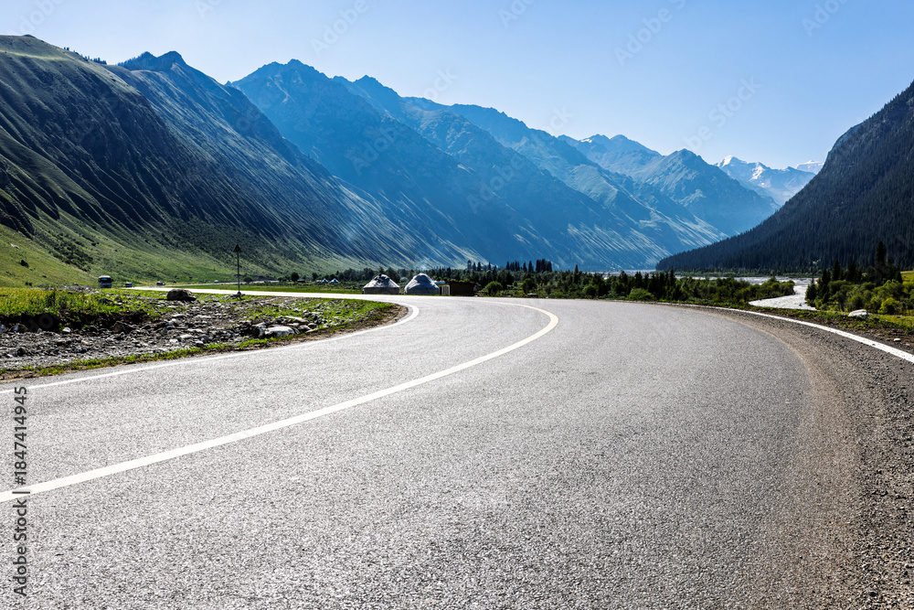 Naklejka premium Empty asphalt road and green mountain natural landscape under blue sky