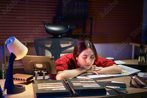 Obraz na płótnie Interior designer resting at desk after long hours reviewing material samples, s