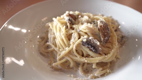 A plate of creamy mushroom spaghetti, dotted with grated Parmesan. This warm Italian dish showcases tender noodles, savory mushrooms, and a rich sauce