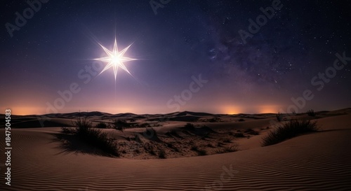 Star of bethlehem over desert landscape at night with milky way and city lights.