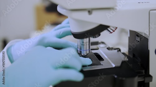 Close up view of microscope objective lenses focusing on a sample. 