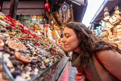 Woman experiencing Istanbul market, smelling traditional turkish spices