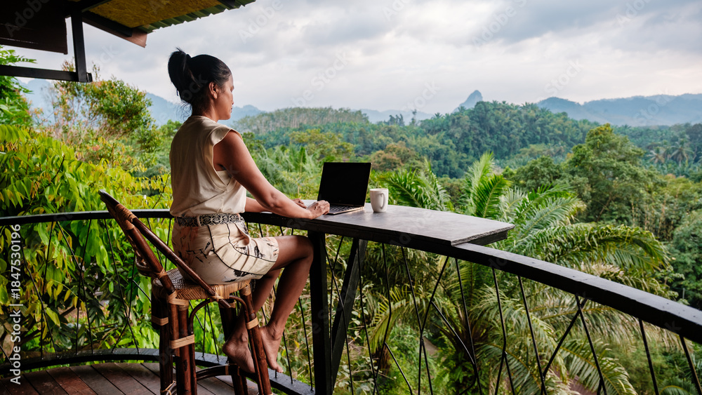 Obraz premium Working from a serene balcony overlooking the lush green landscape of Khao Sok in Thailand