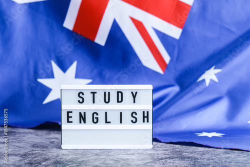 Message STUDY ENGLISH on background of Australian flag made from silk. Australia national flag with concept of tourism and traveling. Welcoming students opportunities scholarship programs 