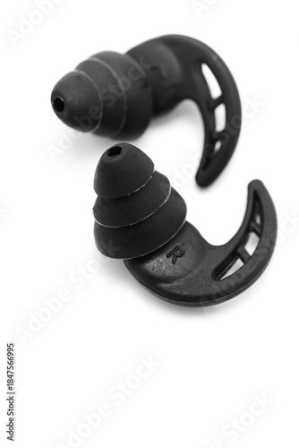 Black earplugs placed on a plain background