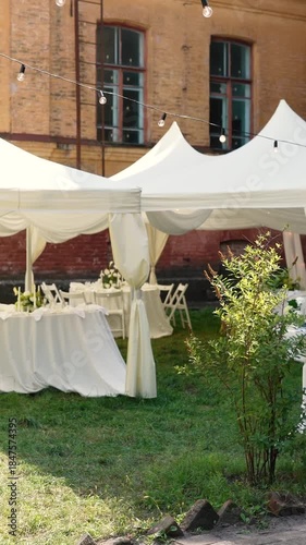 A very beautiful and stylish banquet table with a tent outdoors. Wedding decor and floral arrangements before the ceremony and celebration