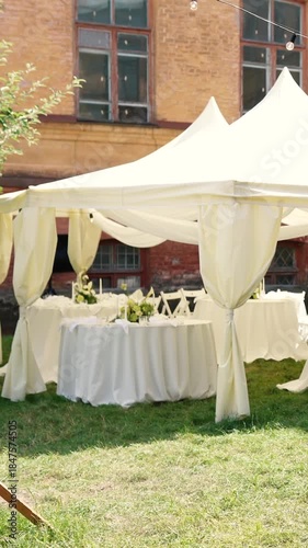 A very beautiful and stylish banquet table with a tent outdoors. Wedding decor and floral arrangements before the ceremony and celebration