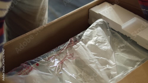 Worker Unpacking Kitchen Appliance from Cardboard Box