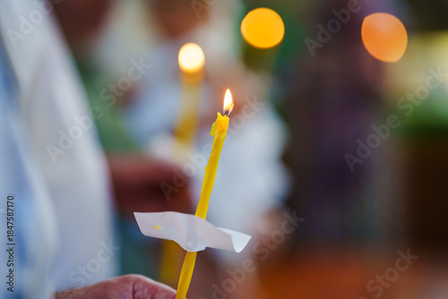 People hold lit candles in a ceremony at a community center