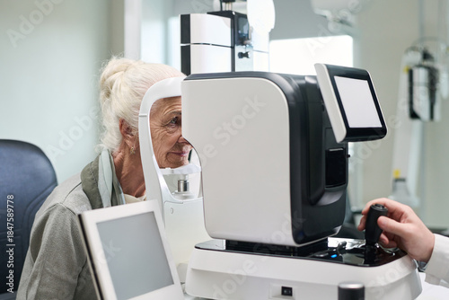 Fotografie Senior Caucasian woman undergoing eye examination using advanced ophthalmology e