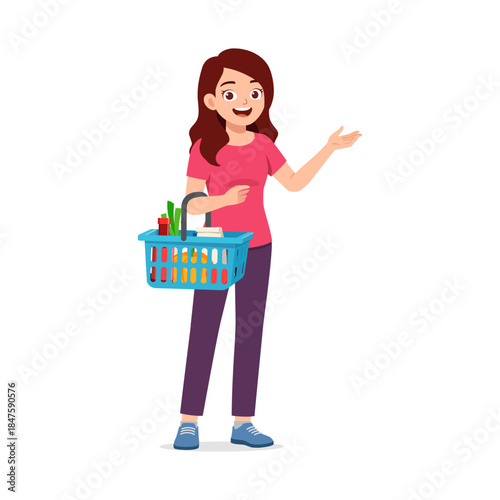 Happy light skinned woman holding a shopping basket full of groceries and gesturing with open hand