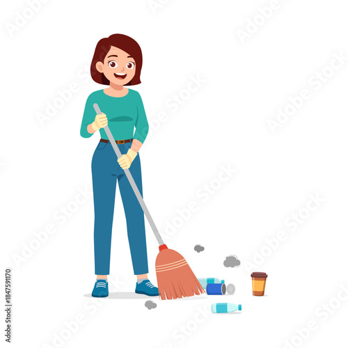 A happy Caucasian woman diligently sweeping up litter with a broom cleaning the floor with a smile
