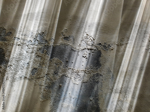 Abstract background of a weathered and rusted corrugated surface with peeling paint.