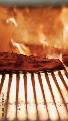 Wallpaper Mural Marinated steak cooking on a grill, receiving heat from intense orange flames, creating sear marks and a delicious sizzle. Torontodigital.ca