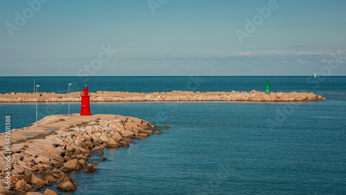 Tableau sur toile Red and green lighthouses mark the harbor entrance in Trani, Italy, set on stone breakwaters surrounded by calm blue Adriatic Sea under a clear sky, creating a peaceful coastal scene