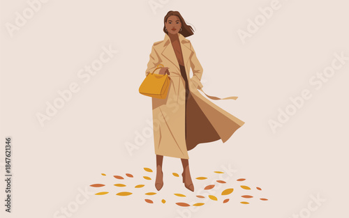 A woman walks through a scattering of autumn leaves, her long beige coat flowing in the wind.