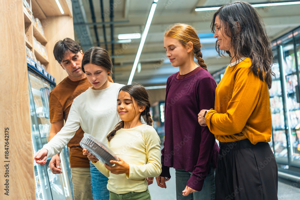 Obraz premium Family shopping for groceries at supermarket with daughters