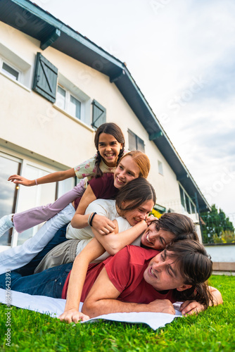 Happy family members piling up laughing together outside
